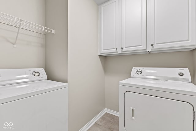 clothes washing area featuring cabinets, independent washer and dryer, and light tile patterned floors