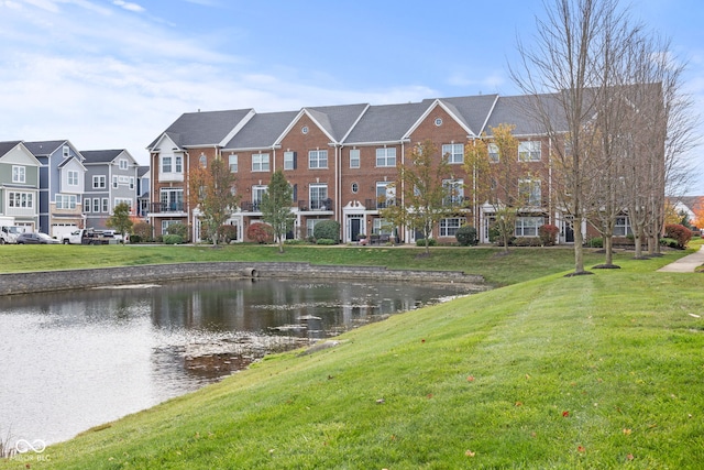 view of home's community featuring a lawn and a water view