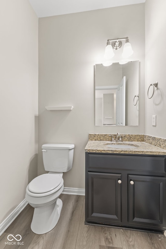 bathroom featuring hardwood / wood-style floors, vanity, and toilet