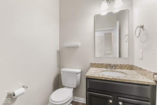 bathroom with vanity, toilet, and wood-type flooring