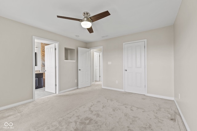 unfurnished bedroom featuring ensuite bathroom, ceiling fan, and light colored carpet