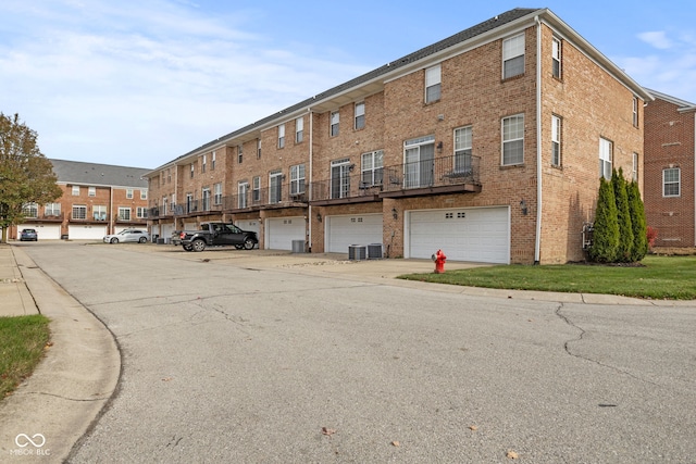 view of building exterior with central AC unit and a garage