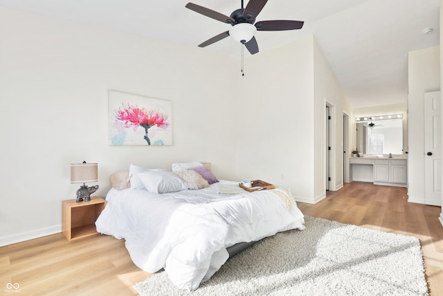 bedroom with vaulted ceiling, ensuite bathroom, light hardwood / wood-style flooring, and ceiling fan