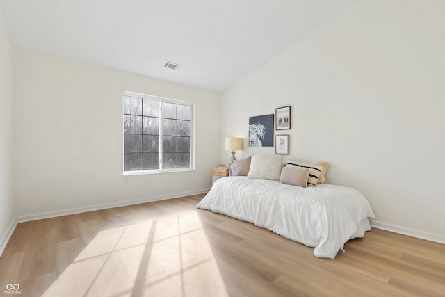 bedroom featuring vaulted ceiling and light wood-type flooring