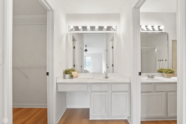 bathroom with hardwood / wood-style floors, vanity, a shower with door, and ceiling fan