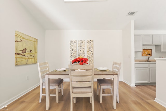 dining area with light wood-type flooring and sink