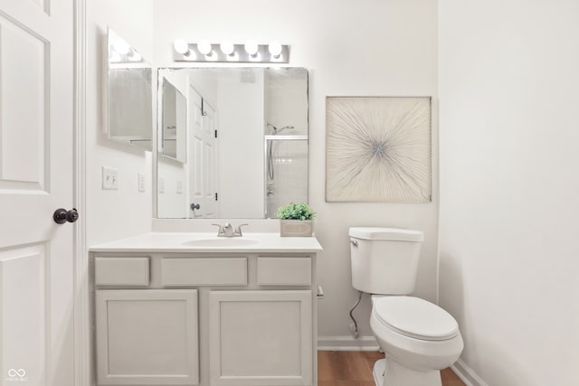 bathroom featuring hardwood / wood-style floors, vanity, toilet, and a shower with shower door