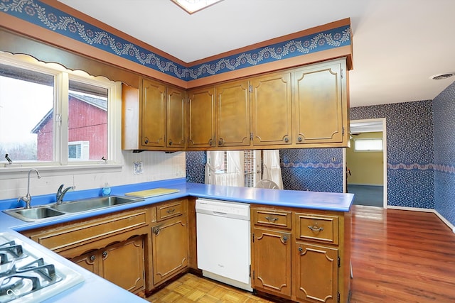 kitchen featuring kitchen peninsula, dishwasher, and sink