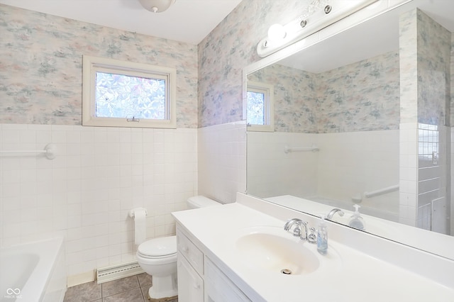 bathroom featuring toilet, tile patterned floors, a wealth of natural light, and tile walls