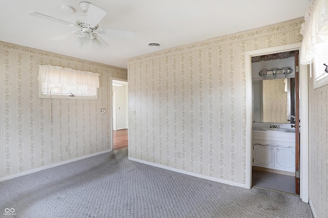 unfurnished room featuring carpet floors, ceiling fan, and sink