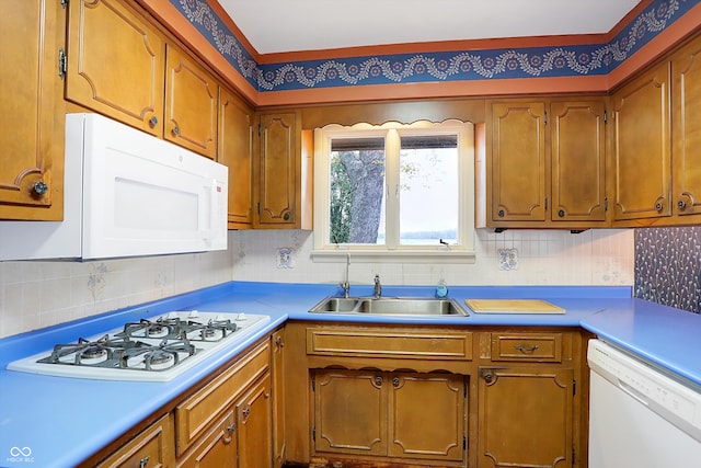 kitchen featuring white appliances, sink, and tasteful backsplash