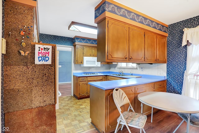 kitchen featuring kitchen peninsula, light parquet floors, and white appliances