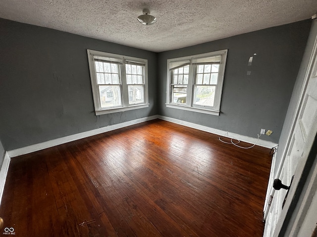 empty room with a textured ceiling and hardwood / wood-style flooring