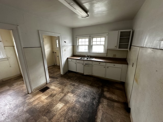 kitchen with dark hardwood / wood-style floors, white cabinetry, and sink