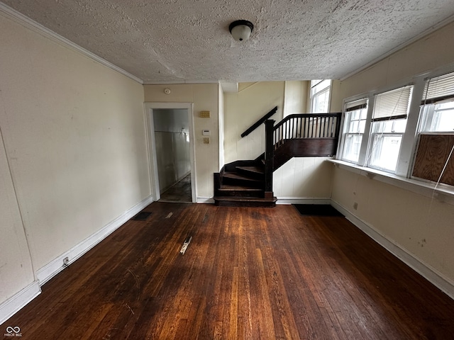 empty room with a textured ceiling and dark hardwood / wood-style flooring