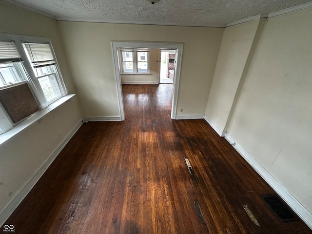 empty room featuring dark hardwood / wood-style flooring and a textured ceiling