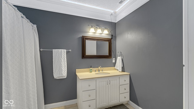 bathroom with crown molding, vanity, and a textured ceiling