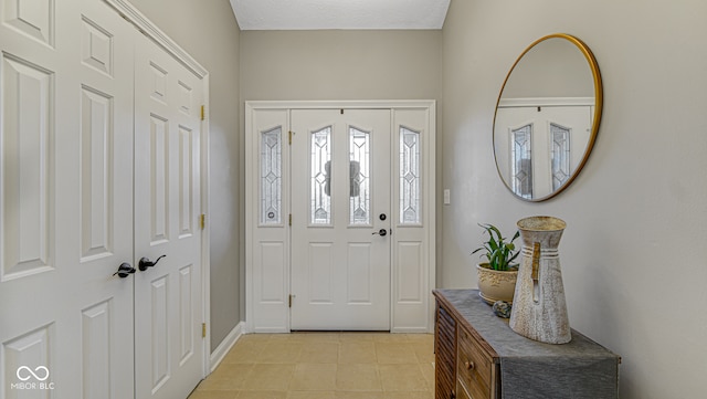 entrance foyer with light tile patterned floors and baseboards