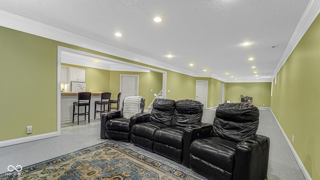 home theater room with ornamental molding and a textured ceiling