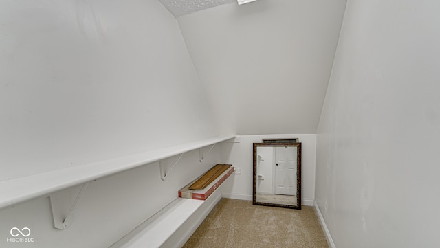 staircase with carpet floors, baseboards, and vaulted ceiling