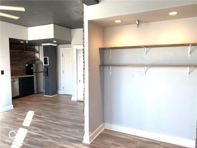 kitchen with kitchen peninsula, wood-type flooring, and stainless steel appliances