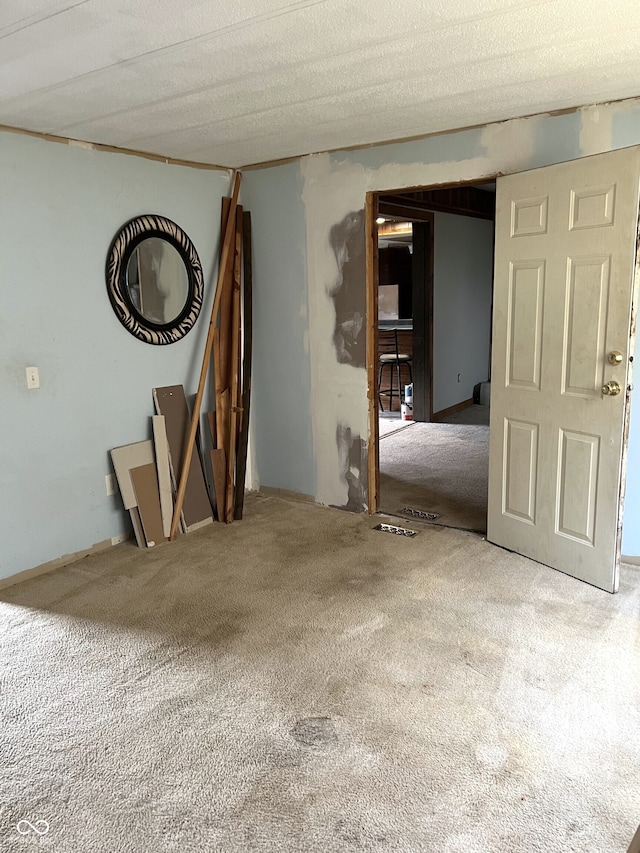 carpeted spare room featuring a textured ceiling