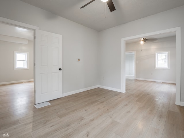 spare room featuring a wealth of natural light, light hardwood / wood-style flooring, and ceiling fan