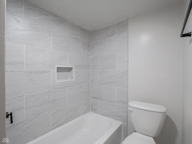 bathroom featuring toilet and tiled shower / bath