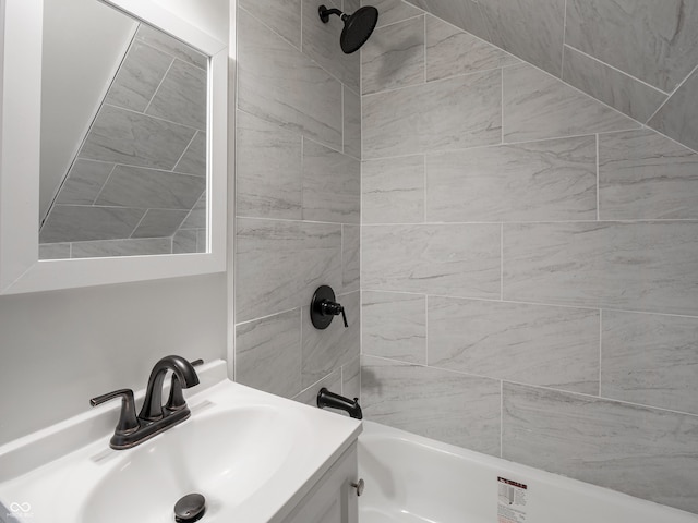 bathroom featuring tiled shower / bath combo and vanity