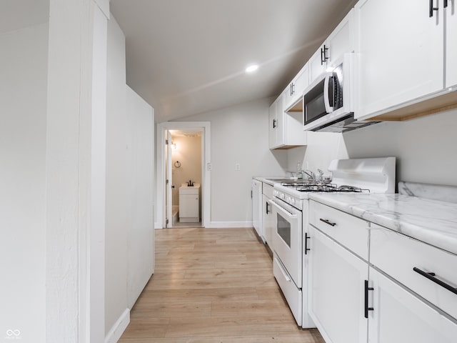 kitchen featuring light stone countertops, light wood-type flooring, white gas stove, white cabinetry, and lofted ceiling