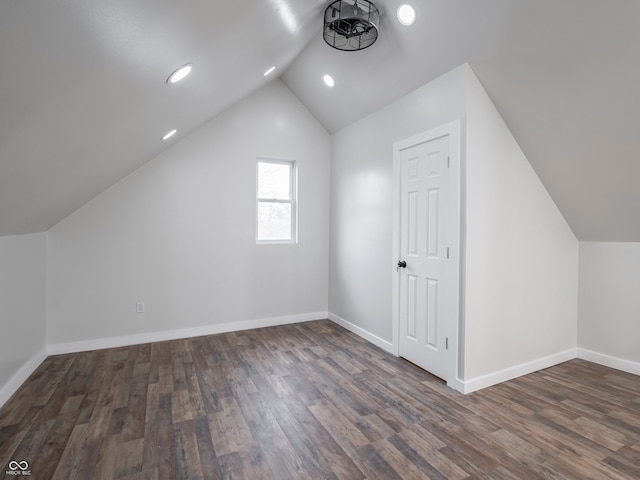 bonus room with dark hardwood / wood-style flooring and vaulted ceiling