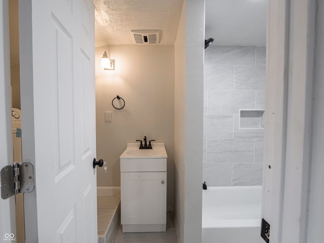 bathroom featuring a textured ceiling and vanity