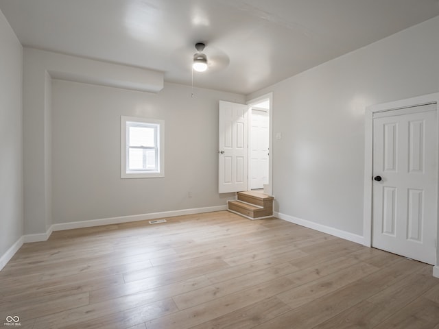 spare room with ceiling fan and light wood-type flooring