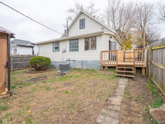 back of property with a lawn, a deck, and central air condition unit