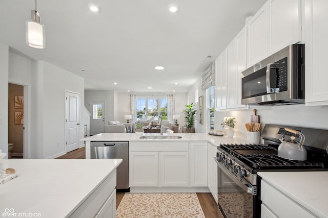 kitchen featuring white cabinetry, sink, stainless steel appliances, and light hardwood / wood-style flooring