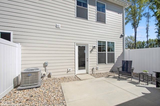 rear view of house with central AC unit and a patio area