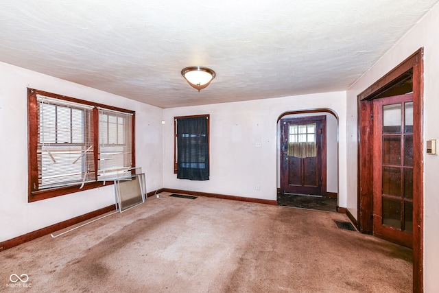 foyer featuring carpet and a textured ceiling