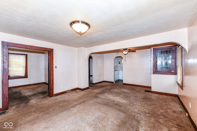 carpeted spare room with a textured ceiling and ceiling fan