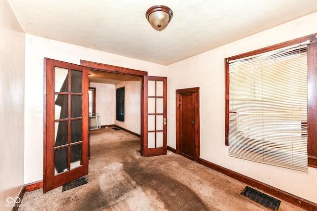 carpeted spare room featuring french doors