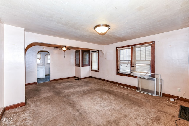 carpeted spare room featuring ceiling fan and a textured ceiling