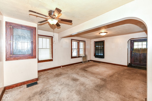 carpeted empty room featuring ceiling fan and a textured ceiling