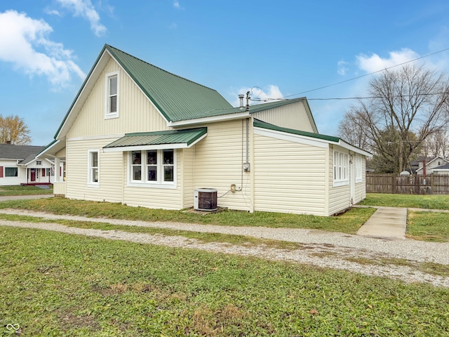 view of side of property with cooling unit and a yard