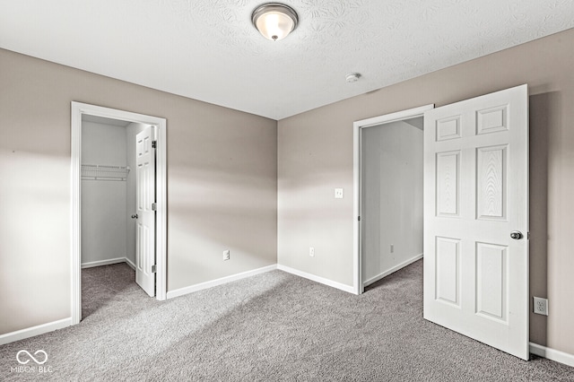 unfurnished bedroom featuring carpet flooring, a textured ceiling, and a closet