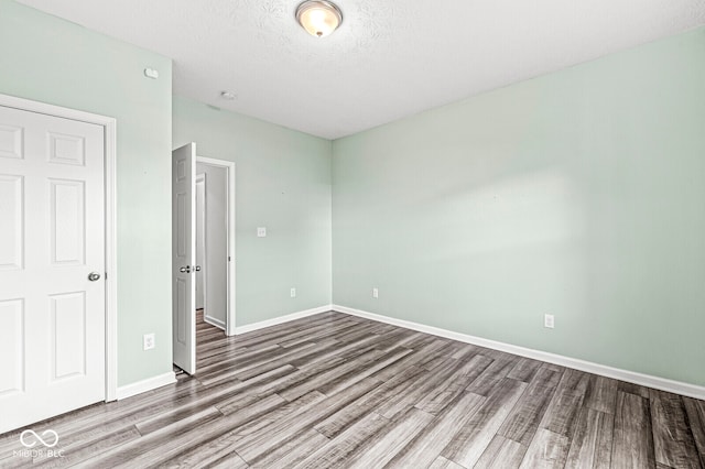 unfurnished bedroom with hardwood / wood-style floors and a textured ceiling