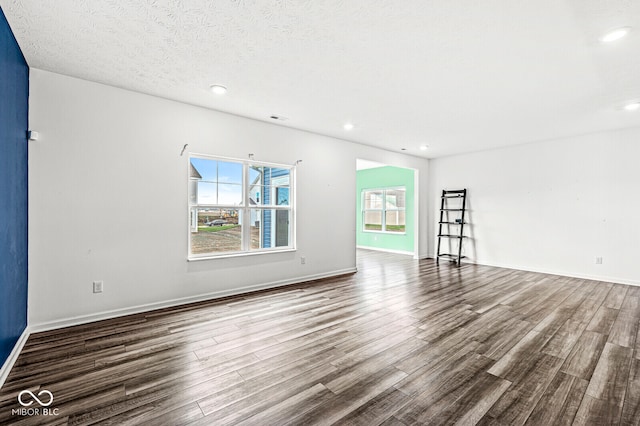 unfurnished room with a textured ceiling and hardwood / wood-style flooring