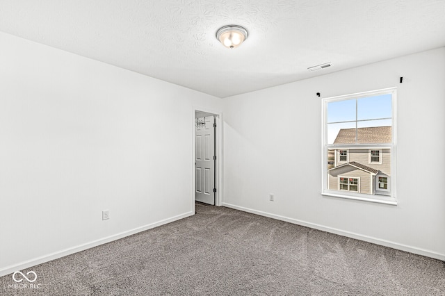 empty room featuring carpet floors and a textured ceiling