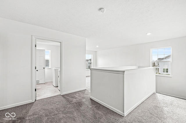 hall with dark carpet and a textured ceiling