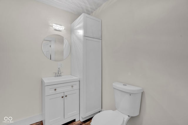 bathroom with hardwood / wood-style flooring, vanity, and toilet