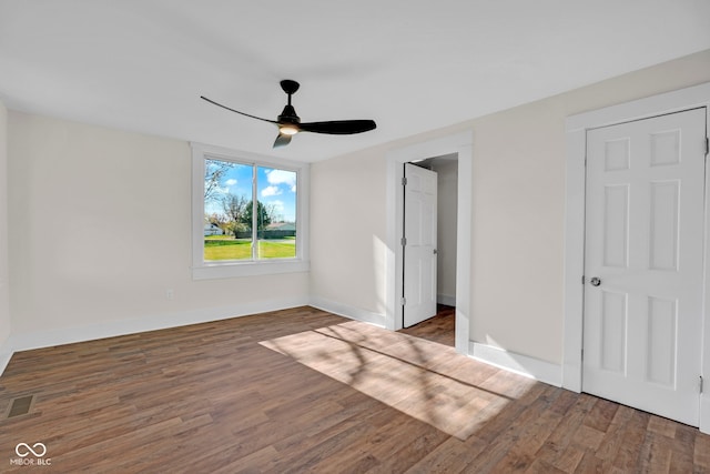 unfurnished bedroom featuring ceiling fan and dark wood-type flooring