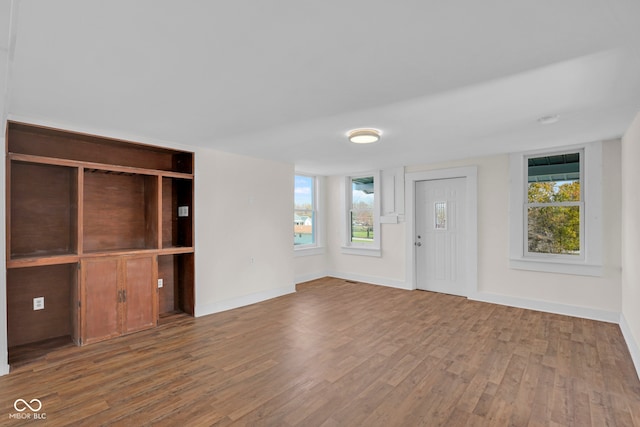 unfurnished living room with hardwood / wood-style floors and a healthy amount of sunlight